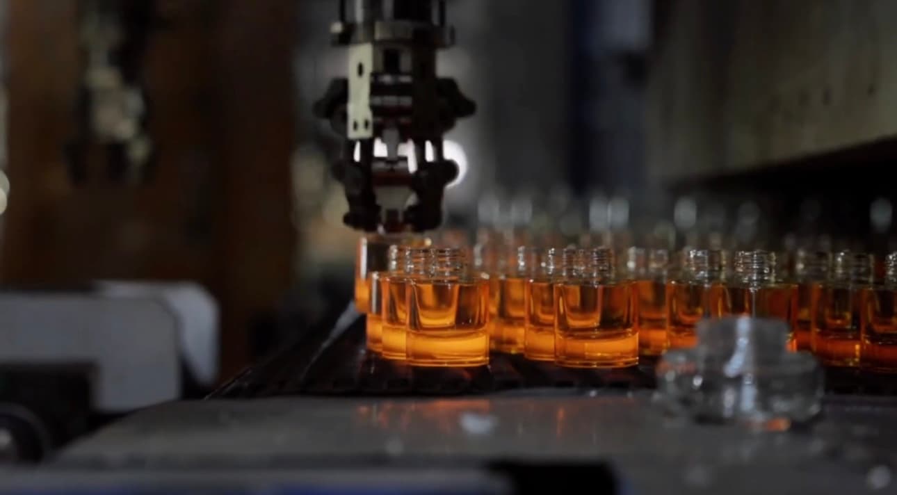 Fresh bottles cooling down on the conveyor toward the lehr