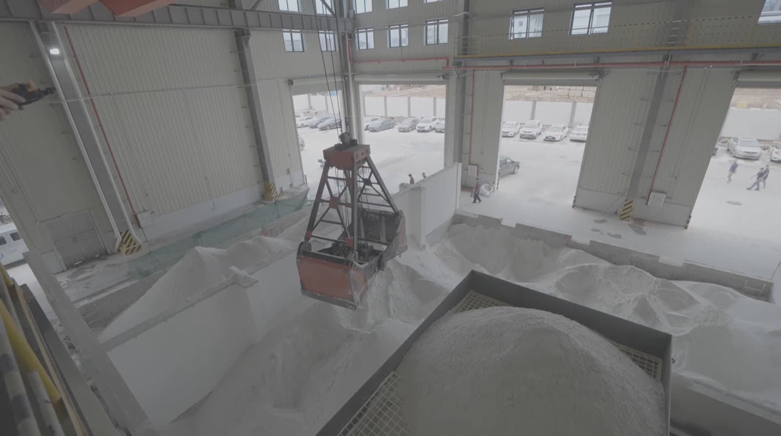 Overhead crane grab moving high-white silica batch in the raw material hall