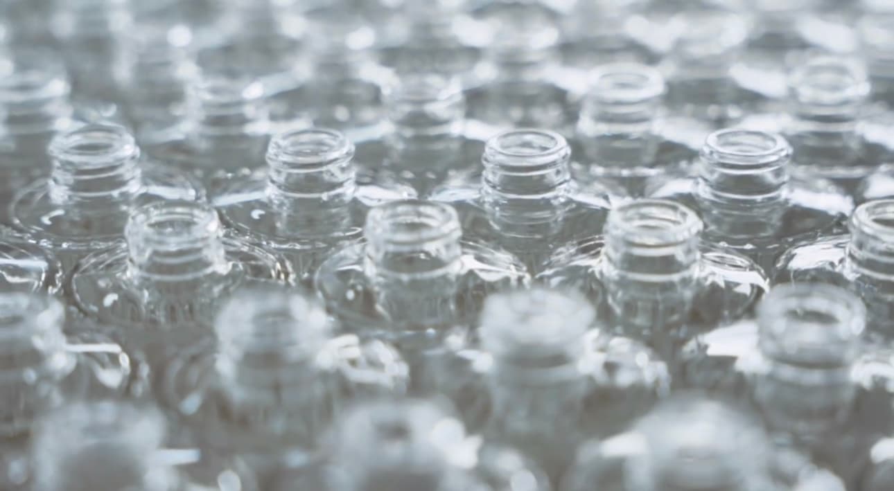 Reihen von Weißglasflaschen bei der Qualitätsprüfung